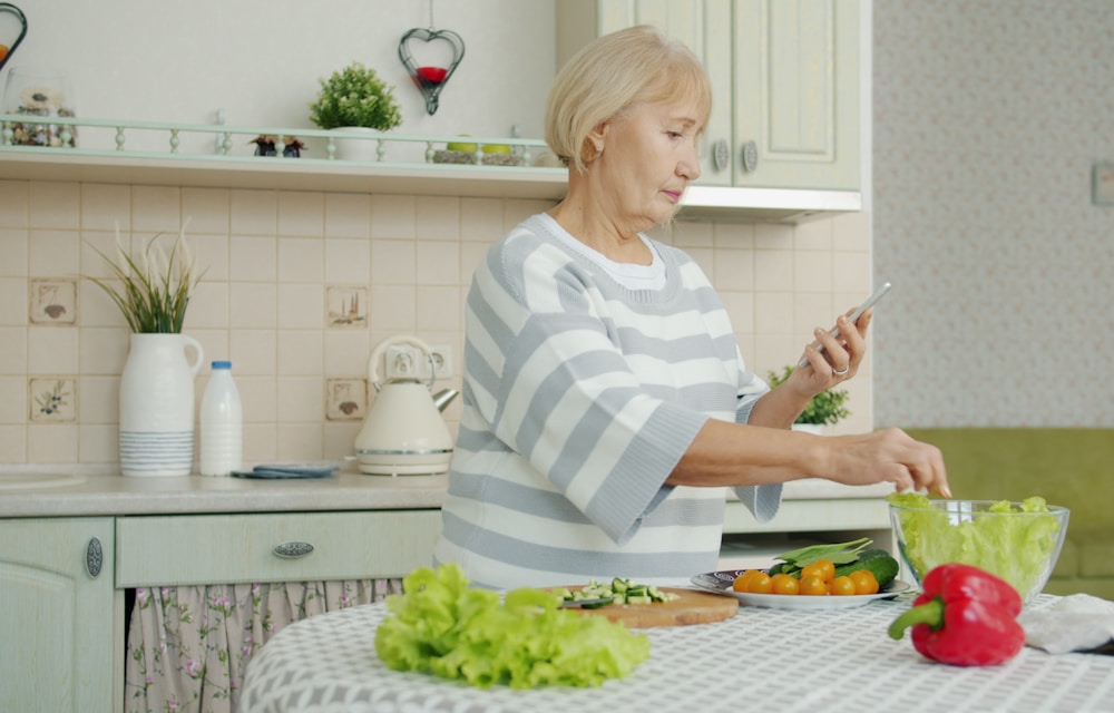Mulher preparando uma salada enquanto segue a dieta pelo aplicativo