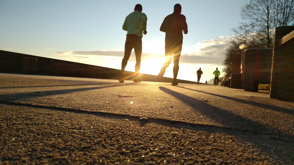 Dois corredores em parque ao amanhecer mostrando intensidade da corrida que emagrece