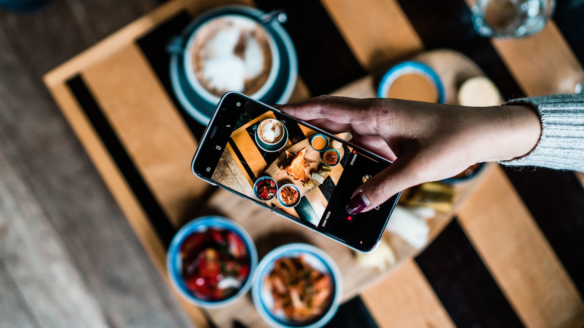 Pessoa fotografando o prato com o celular para registrar no app de contar calorias