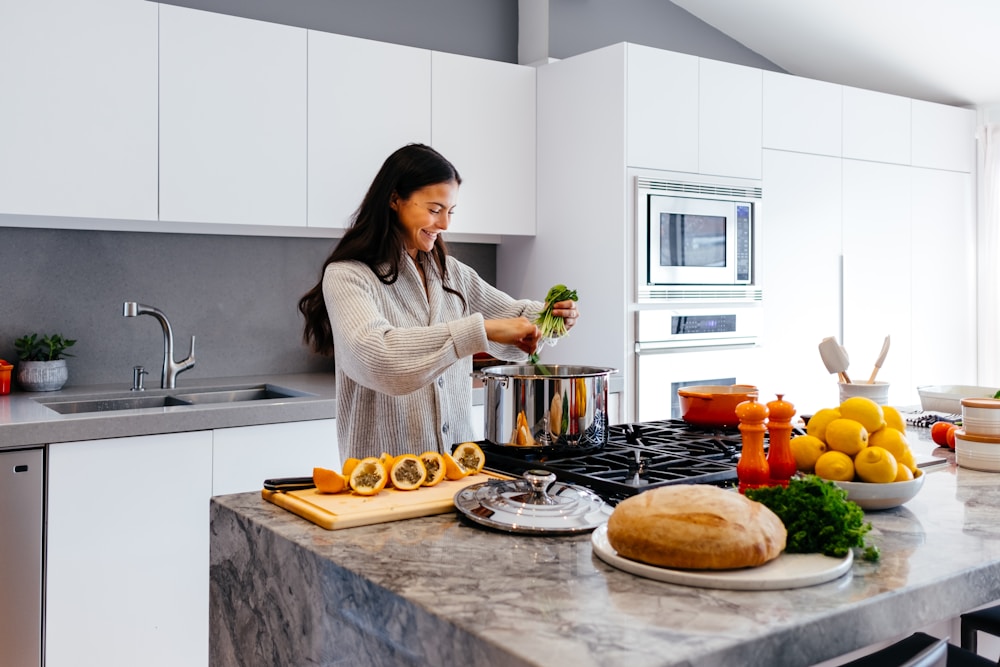 Mulher na cozinha planejando quantas calorias preparar por dia